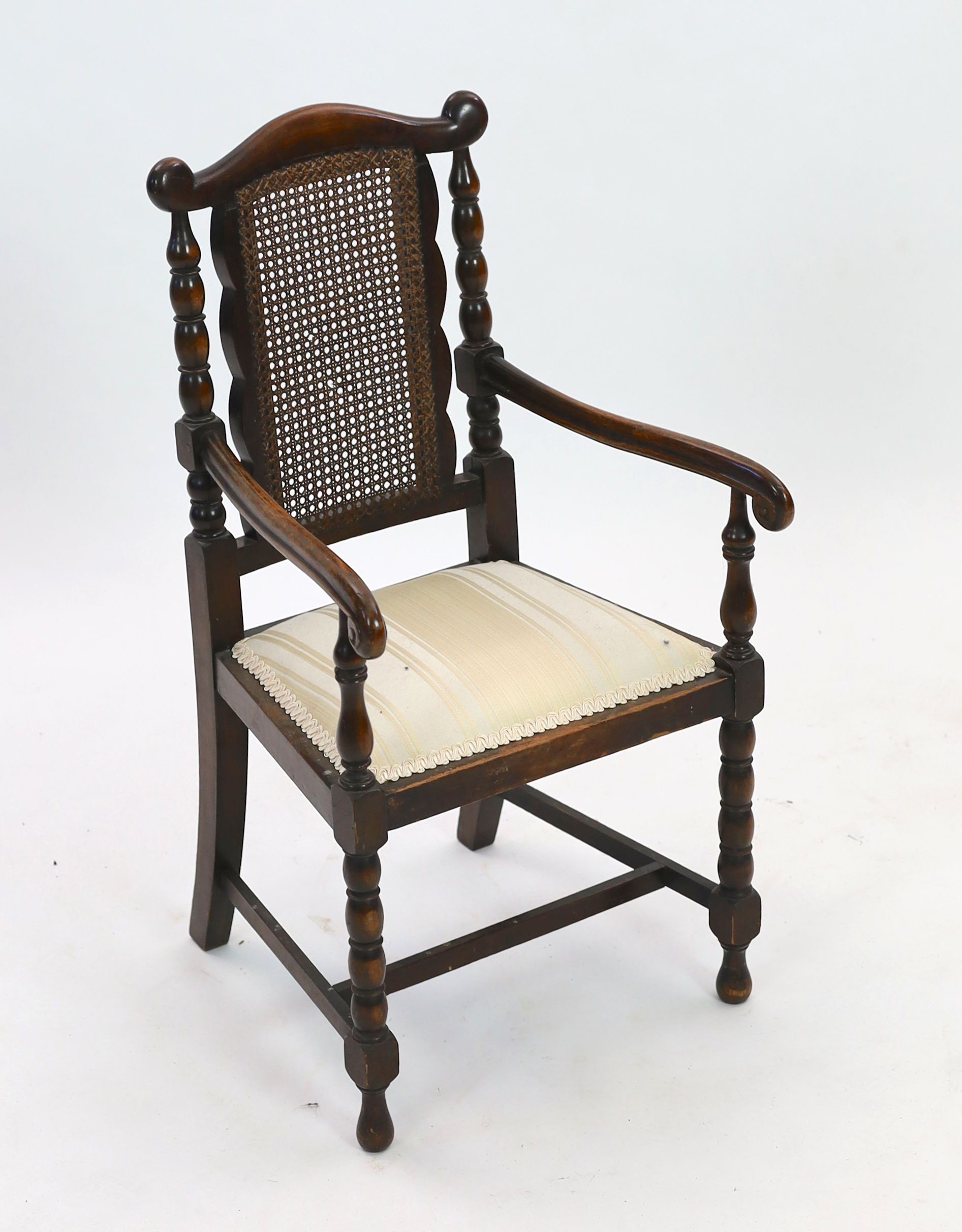 An early 20th century caned beech child's elbow chair